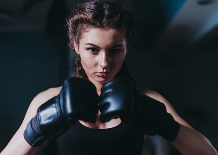 Young fighter boxer girl wearing boxing gloves before  training