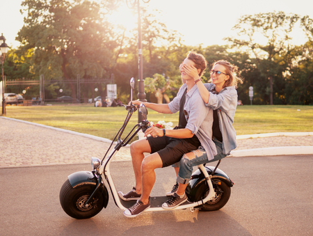 Lovely young happy couple driving electric bikeの写真素材