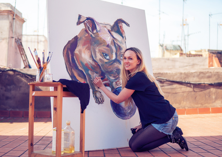 Young woman paint artist drawing at home roofの写真素材