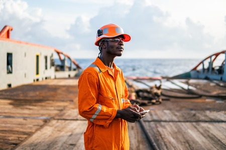 Tired Seaman AB or Bosun on deck of vessel or shipの写真素材