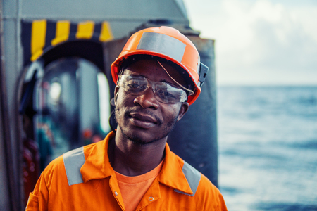 Tired Seaman AB or Bosun on deck of vessel or shipの写真素材