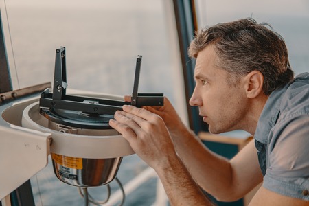 deck officer taking magnetic compass error onboard of vesselの写真素材