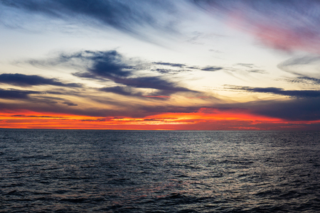 Amazing sunset, sea, the sun with clouds and sun reflection.の写真素材