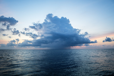 sunset, sea, the sun is covered with clouds. Open ocean viewの写真素材