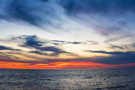 Amazing sunset, sea, the sun with clouds and sun reflection.の写真素材