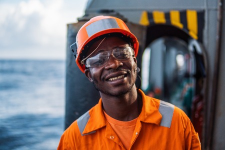 happy Seaman AB or Bosun on deck of vessel or shipの写真素材