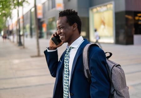 African American businessman holding mobile phone wearing blue suitの写真素材