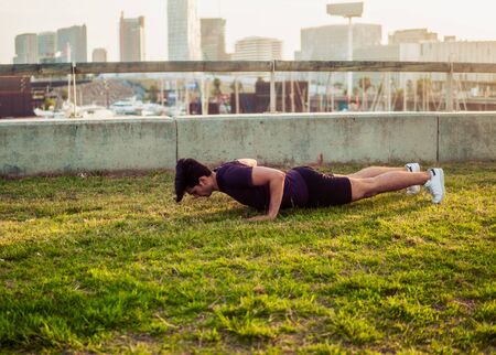 Young athletic man doing pushups exercises at parkの写真素材