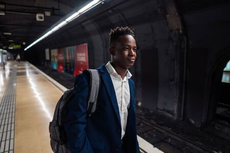 African American businessman wearing blue suit and backpack