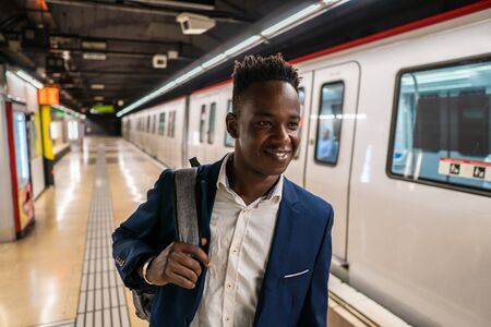 African American businessman wearing blue suit and backpackの写真素材