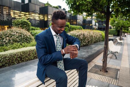 Businessman looking at his watch in officeの写真素材