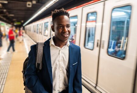 African American businessman wearing blue suit and backpackの写真素材