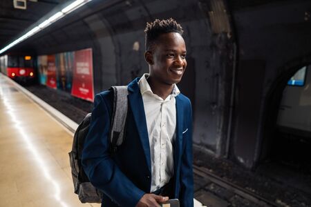 African American businessman wearing blue suit and backpackの写真素材