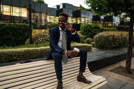 African American businessman holding mobile phone wearing blue suitの写真素材