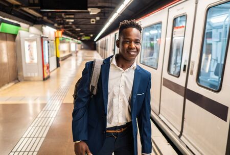 African American businessman wearing blue suit and backpackの写真素材