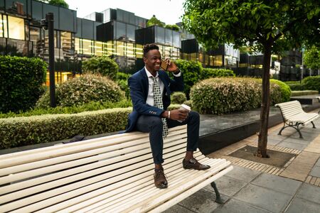 African American businessman holding mobile phone wearing blue suitの写真素材