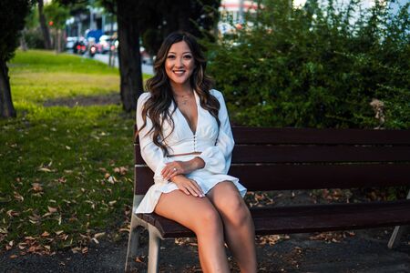 Beautiful Asian girl in white dress smiling in the parkの写真素材