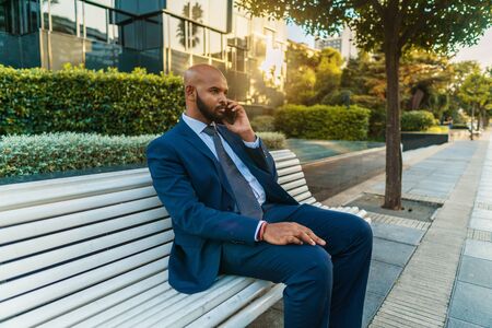 Indian businessman holding mobile phone wearing blue suitの写真素材