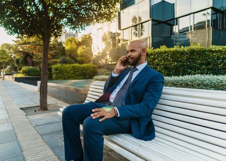 Indian businessman holding mobile phone wearing blue suitの写真素材