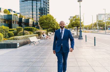 Indian businessman wearing blue suit walking near office or hotelの写真素材