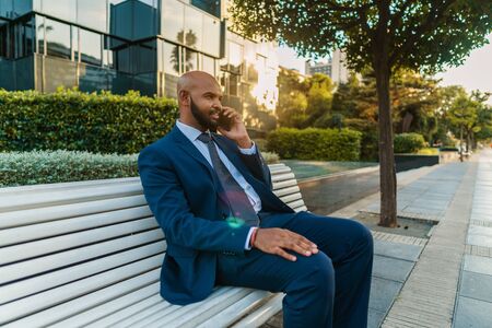 Indian businessman holding mobile phone wearing blue suitの写真素材