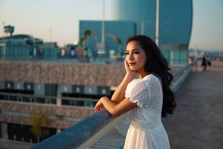 Beautiful girl in the white dress along the sea promenade.の写真素材
