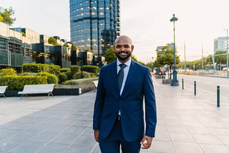 Indian businessman wearing blue suit walking near office or hotelの写真素材
