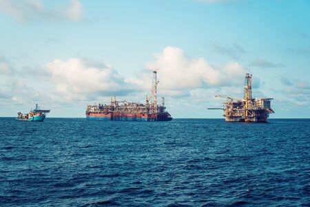 FPSO tanker vessel near Oil Rig platform. Offshore oil and gas industry. Flare is burning with smoke. View from supply vesselの写真素材