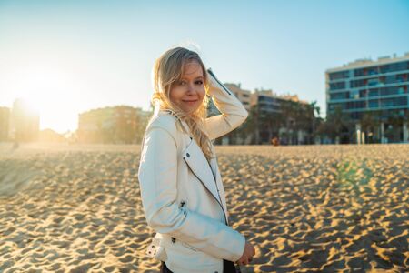 Young woman walking at beautiful ocean beach on sunset