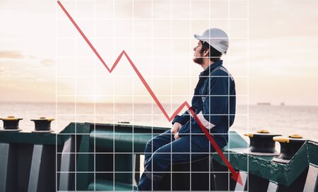 Concept of falling market in marine industry with downward graphics. Marine Deck Officer or Chief mate on deckの写真素材
