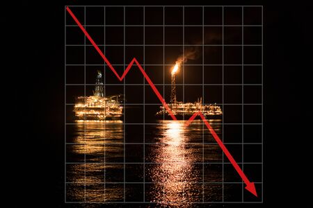 Concept of falling market in oil marine industry with downward graphics. Oil price decreases. FPSO tanker vessel and Oil Rig platform at nightの写真素材