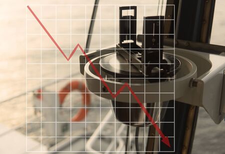 Concept of falling market in marine industry with downward graphics. Magnetic compass