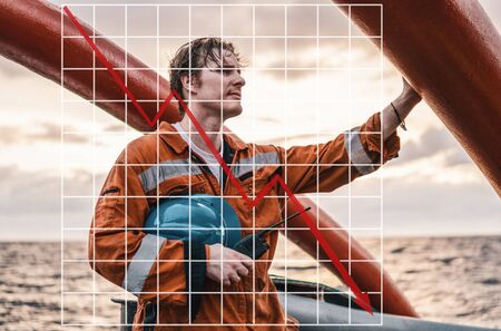 Concept of falling market in marine industry with downward graphics. Marine Deck Officer or Chief mate on deck of shipの写真素材