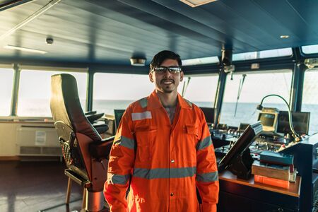 Filipino deck Officer on bridge of vessel or ship during navigaton watch at sea.の写真素材