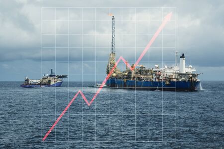 Concept of growth up in oil marine industry with rising graphics. Oil price increases. FPSO tanker with supply diving vessel on oilfieldの写真素材