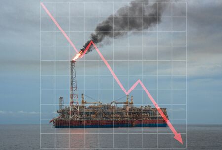 Concept of falling market in oil marine industry with with downward graphics. Oil price decreases. FPSO tanker vessel on oilfieldの写真素材