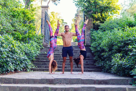 Beautiful man and two women practicing acroyoga