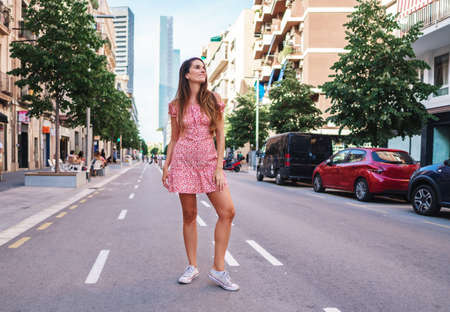 woman in sexy stylish dress posing in the city with standing on the roadの写真素材