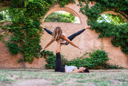 Two beautiful women doing acroyoga in the garden or parkの写真素材