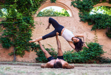 Two beautiful women doing acroyoga in the garden or parkの写真素材