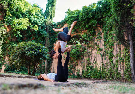 Two beautiful women doing acroyoga in the garden or parkの写真素材