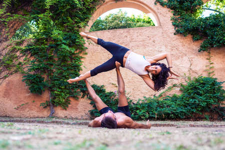Two beautiful women doing acroyoga in the garden or parkの写真素材