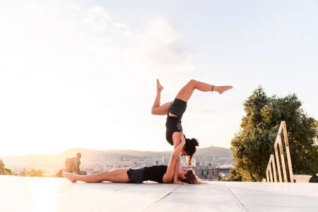 Two beautiful women doing acroyoga in the city