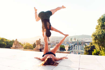Two beautiful women doing acroyoga in the cityの写真素材