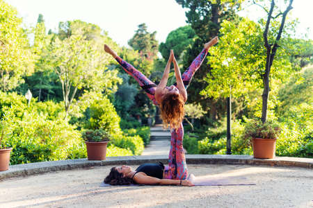 Two beautiful women doing acroyoga in the garden or parkの写真素材