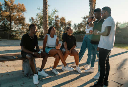 Group of young modern african black friends happily sitting togetherの写真素材