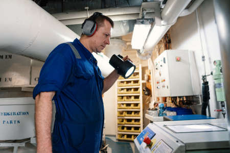 Marine engineer officer controlling vessel enginesand propulsion in engine control room ECRの写真素材