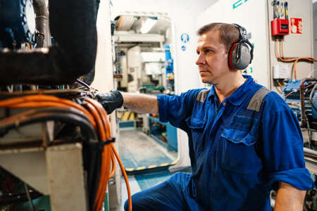 Marine engineer officer controlling vessel enginesand propulsion in engine control room ECRの写真素材