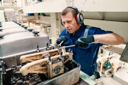 Marine engineer officer controlling vessel enginesand propulsion in engine control room ECR