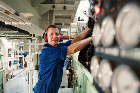 Marine engineer officer controlling vessel enginesand propulsion in engine control room ECRの写真素材